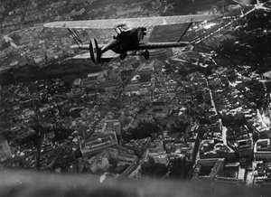روما (إيطاليا) ، حوالي عام 1930: حلّق وزير الطيران الإيطالي إيتالو بالبو (1896-1940) فوق المدينة على متن طائرة ذات سطحين "Ro1" أثناء العرض الجوي الذي أقيم لافتتاح صالون السياحة - روما ، إيطاليا ، حوالي عام 1930: إيطاليا وزير الطيران بواسطة فنان غير معروف