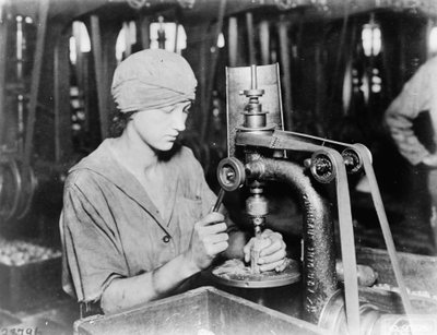 امرأة ثقب أنبوب مفجر غاطس وفتحة تعبئة في قنبلة يدوية في Westinghouse Electric & Mfg. Co. ، شرق بيتسبرغ ، بنسلفانيا ، خلال الحرب العالمية الأولى ، 1914-1918 بواسطة مصور أمريكي