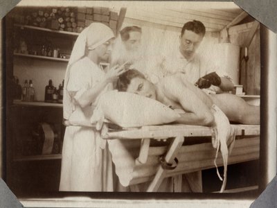 الحرب العالمية الأولى 1914-1918: أطباء وممرضون يعالجون جروح جندي في غرفة تبديل الملابس ، معسكر كوفيل في القنال الإنجليزي ، نورماندي السفلى (نورماندي السفلى) ، فرنسا. صورة مجهولة ، يوليو 1917. مجموعة خاصة ، ستيلا. بواسطة مجهول مجهول