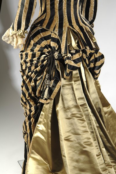 فستان سهرة ، حوالي 1884 (منظر خلفي مائل للتفاصيل الصاخبة). الساتان والحرير وقطع المخمل والدانتيل وشرابات خيط الحرير والهامش. تشارلز فريدريك ورث ، فرنسا. بواسطة تشارلز فريدريك وورث