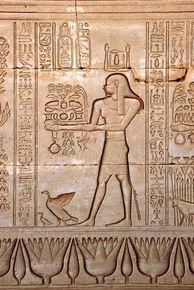 الآثار المصرية: تمثيل لرجل يقدم قرابين للإلهة ، معبد حتحور ، دندرة ، مصر - الحضارة المصرية: رجل يحمل قرابين للإلهة حتحور ، منحوت على جدار معبد حتحور (أو معبد تينتيرا) في دندرة بواسطة الفترة البطلمية المصرية