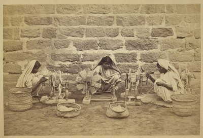 سجينات يلفن القطن على عجلات دوارة في سجن كراتشي. المصور: Michie and Company c. مجموعات المسح الأثري للهند 1873173 مم × 260 مم: سلسلة مكتب الهند (المجلد 52). بواسطة مصور انجليزى