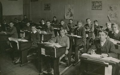 التلاميذ الذكور يجلسون خلف مكاتبهم خلال درس في المدرسة بواسطة مصور انجليزى