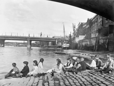 أطفال على الجسر المرصوف بالحصى تحت جسر ساوثوارك ، لندن ، عام 1930 بواسطة جورج دافيسون ريد