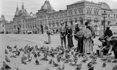 إطعام الحمام في الساحة الحمراء، الصفوف التجارية العليا في الخلفية. الصفوف التجارية العليا... بواسطة جيلبرت إتش جروسفينور