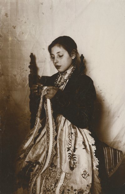 امرأة شابة تقوم بالخياطة، توسكانا، إيطاليا، حوالي عام 1910 بواسطة مصور إيطالي
