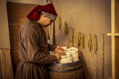 Historical reenactment: Candles and sacks of wheat, rye and barley in the apothecary of Diotaiuti, Imola, Italy, mid-14th century (photo) بواسطة غير معروف غير معروف