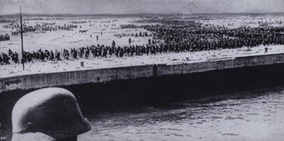 جندي ألماني يقوم بمسح سجناء الحلفاء على الشاطئ في دونكيرك ، فرنسا ، الحرب العالمية الثانية ، يونيو 1940 (صورة بالأبيض والأسود) بواسطة مصور فوتوغرافي ألماني