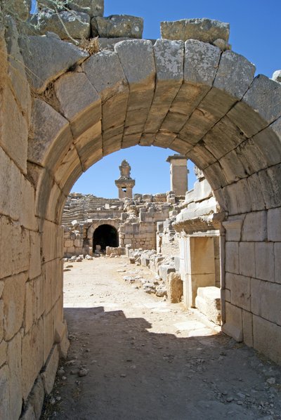 منظر من خلال المدخل المقبب لمسرح Xanthos في حفرة الأوركسترا ، يُظهر العمود وقبر Harpy ، Xanthos ، تركيا (صورة) بواسطة رواية