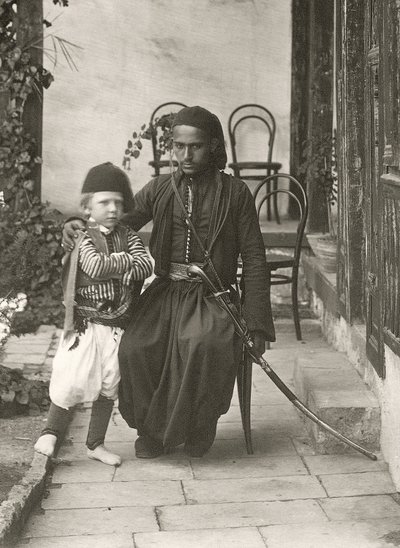 القواس العربي (الحرس العثماني) مع صبي صغير في حديقة منزل في منطقة يهودا بالقدس ، 1867 بواسطة الرقيب هنري فيليبس