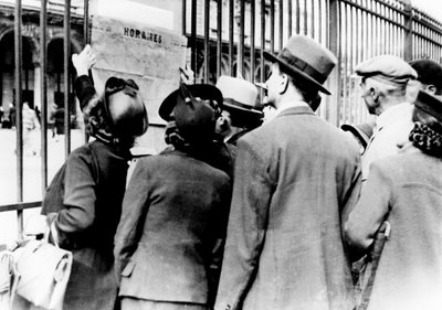 اللاجئون الذين يدرسون الجدول الزمني للقطار ، غار دي ليست ، باريس ، يوليو 1940 بواسطة غير معروف