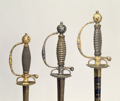 تلال لثلاثة سيوف فرنسية: واحد من الصلب ، أزرق ومغطى بتصاميم من الذهب المطارد ، c.1730 ؛ واحدة من الفولاذ المثقوب والمنقوش وأرضية الذهب المطفأ ، c.1760 ؛ واحدة من الصلب المحفور ، غرام بواسطة غير معروف غير معروف