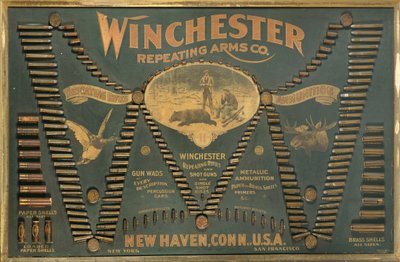 لوحة عرض خرطوشة Winchester ، مع مجموعة شاملة من البنادق المعدنية والنحاسية والورقية وخراطيش الطلقات مرتبة في شكل "W" ممتد بواسطة غير معروف