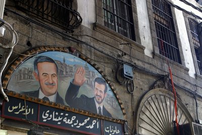 لوحة للرئيس الأسد ونجله باسل فوق سوق دمشق ، سوريا. بواسطة غير معروف