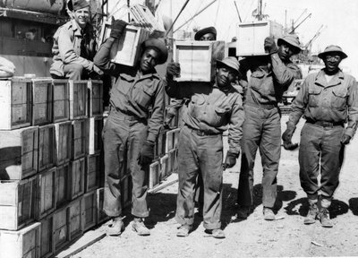 الحرب العالمية الثانية (1939-1945) - الشرق الأوسط أبريل 1943: في أحد الموانئ ، قام أعضاء من كتيبة الموانئ التابعة للجيش الأمريكي من الأفرو-أمريكيين بتفريغ المعدات العسكرية. بواسطة غير معروف