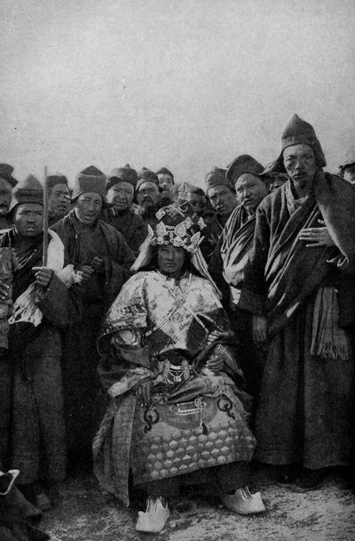 التبت. ساحر بملابسه الكاملة وفرقة رهبان معجبة. 1920 بواسطة غير معروف
