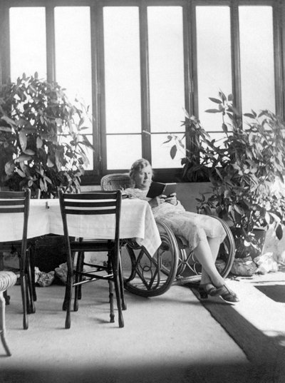 امرأة تجلس على كرسي هزاز، تقرأ كتاباً. 1915 تقريباً. ألمانيا صورة تاريخية، امرأة تقرأ، 1915 تقريباً بواسطة فنان غير معروف