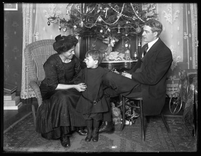 دان سيمور وعائلته في وضع غير رسمي ، جالسين تحت شجرة عيد الميلاد ، عيد الميلاد عام 1912 بواسطة وليام ديفيس هاسلر
