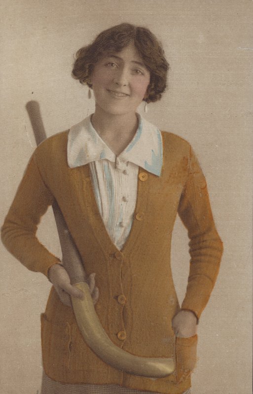 Pretty girl, in knitted jumper, with pearl earrings, holding hockey stick (photo) بواسطة مصور انجليزى