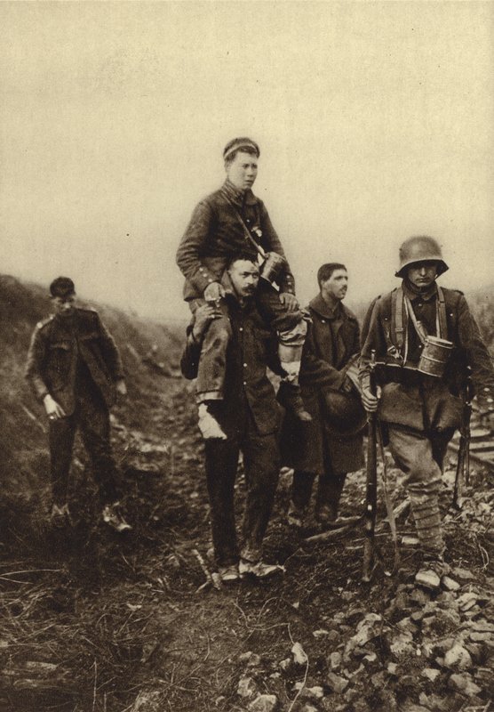 German infantryman with a leg wound being carried from the battlefield by British prisoners, World War I بواسطة مصور فوتوغرافي ألماني